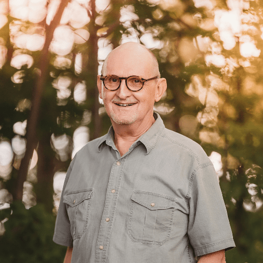 Smiling man with glasses in the woods