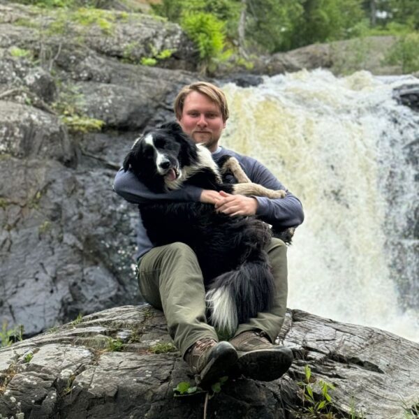 Isaac Burrell with his dog in front of a waterfall