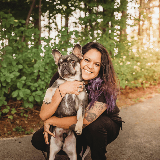 Woman holding Frenchie dog and smiling