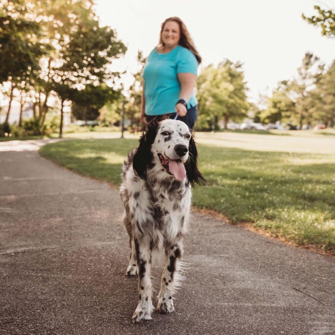 Stephanie walking her dog in the park
