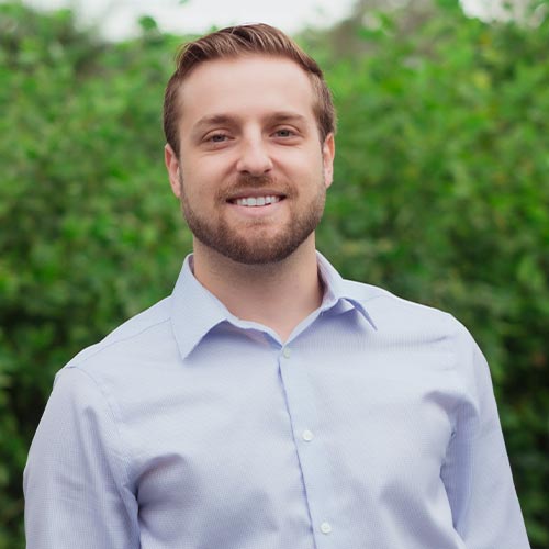 Dr Alex Schenk smiling and posing outside